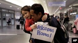 លោក ធី ជា ពលរដ្ឋ​អាមេរិកាំង​ដើម​កំណើត​ខ្មែរ ​​​​​ឱបកូនស្រី​របស់​លោក ពេល​ត្រឡប់​​មក​ដល់​អាកាសយានដ្ឋាន ​Logan ក្នុង​ទីក្រុង Boston រដ្ឋ Massachusetts សហរដ្ឋអាមេរិក ថ្ងៃ​ទី​២៦ ខែកុម្ភៈឆ្នាំ២០២០។