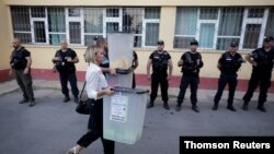 Election workers carry ballot boxes to a local election counting centre in Shkodra, Albania, June 30, 2019.