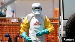FILE - A health worker dressed in a protective suit disinfects an ambulance transporting a suspected Ebola patient to the newly constructed MSF (Doctors Without Borders) Ebola treatment center in Goma, Democratic Republic of Congo, Aug. 4, 2019.