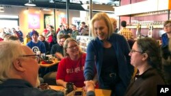 Sen. Kirsten Gillibrand, D-N.Y. greets patrons at Stomping Grounds Cafe in Ames, Iowa, on Saturday, Jan. 19, 2019.