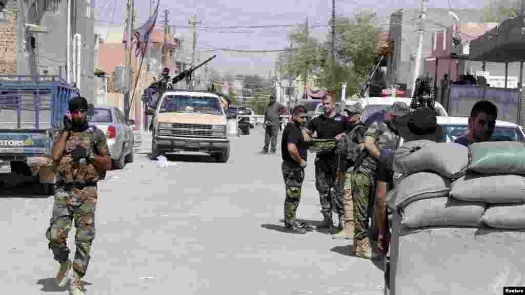 Shi'ite volunteers are seen with their weapons during an intensive security deployment to fight against militants of the Islamic State, formerly known as the Islamic State of Iraq and the Levant (ISIL), in the town of Tuz Khurmatu, Iraq, Aug. 31, 2014. 