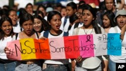 Students hold a sign that reads in Spanish "It's not three, it's all of us" during a protest against the murder of three film students who have become emblematic of Mexico's missing, in Guadalajara, Mexico, April 26, 2018. 