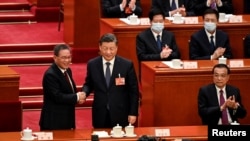 习近平(中)与李强握手，右一位卸任的总理李克强。