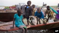A group of displaced brothers and sisters cautiously disembark from a boat that carried them across the Nile to a village in Awerial, which has received tens of thousands of displaced people, who crossed the river to flee fighting between government and rebel forces in the town of Bor, in South Sudan Friday, Jan. 17, 2014.
