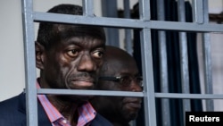 FILE - Ugandan four-time presidential aspirant Kizza Besigye stands in steel dock at Uganda Military General Court Martial in Kampala, Nov. 20, 2024. Besigye disappeared in neighboring Kenya and resurfaced later in a military court in Kampala.