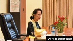 លោក​ស្រី​ អង់​សាន ស៊ូជី នៅក្នុង​ការិយាល័យ​​ក្នុង​អំឡុង​ពេល​ថ្ងៃសម្រាក​បុណ្យ​អ៊ុំទូក​របស់​ប្រទេស​ភូមា (១៤ មេសា​២០១៦)។