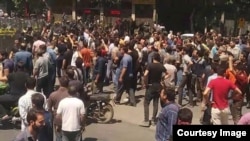 Pasukan keamanan Iran (berpakaian hitam) menghadapi demonstran anti-pemerintah di kota terbesar ke-3 Iran, Isfahan, dalam aksi protes yang dimulai sejak 31 Juli 2018 dan berlanjut untuk hari kedua pada 1 Agustus. (Foto courtesy: Radio Farda)