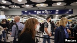 FILE - Arriving passengers queue at UK Border Control at Terminal 5 at Heathrow Airport in London, Britain, June 29, 2021.