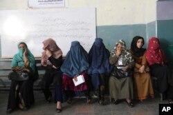 Wanita Afghanistan menunggu tempat pemungutan suara dibuka di Kabul, Afghanistan, Sabtu, 28 September 2019. (Foto: Associated Press)