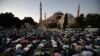 FILE - Muslims offer their evening prayers outside the Byzantine-era Hagia Sophia in Istanbul, following Turkey's decision allowing the government to convert the museum back into a Muslim house of worship, July 10, 2020. 