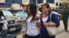 Kum Chandaraty, left, walks with her lawyer, Try Chhoun, after being questioned by the Ministry of Interior’s anti-terrorism department on Friday. (Photo: Neou Vannarin/VOA Khmer) 