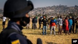 An armed policeman patrols as Police Minster Bheki Cele visits Phoenix, a neighborhood severely affected by unrest and racial tensions near Durban, South Africa, July 17, 2021.
