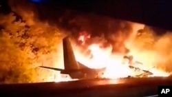 In this TV grab released by Ukraine's Emergency Situations Ministry, an An-26 military plane bursts into flames after crashing in the town of Chuhuyiv near Kharkiv, Ukraine, Sept. 25, 2020.