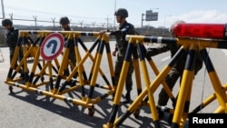 Tentara Korea Selatan berpatroli di jembatan Unifikasi yang menghubungkan negara itu dengan kompleks Industri Kaesong di Korea Utara, selatan zona demiliterisasi korea selatan di Paju, utara Seoul (29/4).