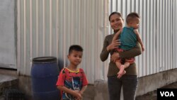 អ្នកស្រី​ ស៊ឹម​ អាក់ វ័យ​២៩ និង​កូន​ប្រុសពីរនាក់​ ដែលមានអាយុ ៥ខែ និង​៥ឆ្នាំ នៅភូមិ​ស្នៀង​ ឃុំ​​ស្វាយ​តាយាន​ ខេត្ត​ស្វាយរៀង នៅថ្ងៃ​ទី​១១ ខែ​តុលា ឆ្នាំ២០១៩។ (ខាន់​ សុគុំមនោ​/VOA)