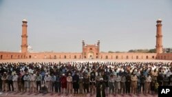 FILE - Small numbers of people offer Friday prayers at the grand Badshahi mosque, due to coronavirus outbreak, in Lahore, Pakistan, March 20, 2020.