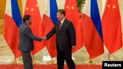 Chinese President Xi Jinping (R) shakes hands with Philippines President Rodrigo Duterte prior to their bilateral meeting during the Belt and Road Forum, at the Great Hall of the People in Beijing, China, May 15, 2017