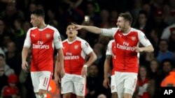 Aaron Ramsey d’Arsenal, à droite, pointe un de doigt un ses co-équipiers après avoir marqué un but contre Lincoln City lors d’un match de quarts de finale du championnat anglais au stade Emirats à Londres, 11 mars 2017.