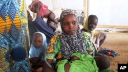 FILE - A family of refugees that fled their homes due to violence from the Islamic extremist group Boko Haram sit inside a refugee camp in Minawao, Cameroon, Feb. 25, 2015.