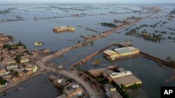 FILE - Homes are surrounded by floodwaters in Sohbat Pur city, a district of Pakistan's southwestern Baluchistan province, August 29, 2022. . (AP Photo/Zahid Hussain, File)