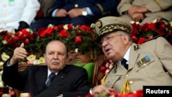 FILE - Then-Algeria's President Abdelaziz Bouteflika gestures while talking with Army Chief of Staff Lt. Gen. Ahmed Gaed Salah during a graduation ceremony at a military academy in Cherchell, west of Algiers.