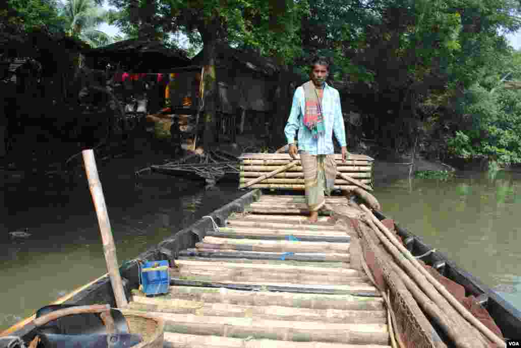 On the fishing boat, otters are kept in a bamboo crate until they are released into the river for their day's work. (Amy Yee for VOA)