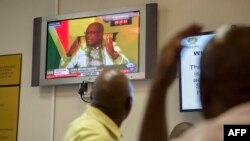 Des visiteurs du Parlement regarde le président Zuma, au Cap, le 14 février 2018.