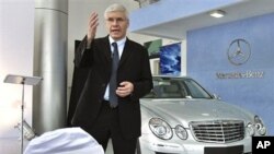 DaimlerChrysler India Managing Director and Chief Executive Officer Wilfried Aulbur stands next to a Mercedes E-280 as he speaks during an event