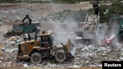 A truck unloads garbage at a landfill at Tseung Kwan O district in Hong Kong, China, June 9, 2017. 