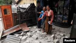 Warga meninggalkan rumahnya yang rusak karena gempa di kabupaten Bener Meriah (2/7). (Foto: Reuters)