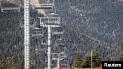 In this file photo, chairlifts are pictured over ski slopes closed due to lack of snow, at the ski resort of The Mourtis in Boutx, France, February 10, 2020. (REUTERS/Regis Duvignau)