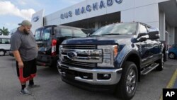 FILE - A potential customer looks at a Ford F-250 Lariat FX4 at a Ford dealership, in Hialeah, Florida, Jan. 17, 2017.