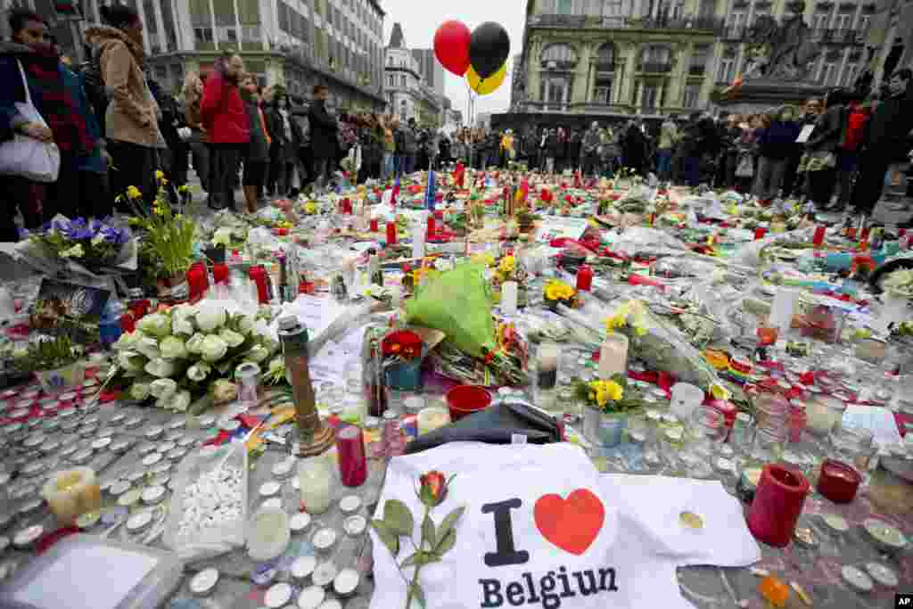 Three balloons in the colors of the Belgian flag fly as people mourn for the victims of the bombings at the Place de la Bourse in the center of Brussels, Belgium, March 24, 2016. 
