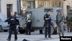 Israeli policemen stand guard near the scene where two Palestinians, who the Israeli military said stabbed and wounded an Israeli soldier, were shot dead by Israeli forces, in the village of Hewara, near the West Bank city of Nablus, Dec27, 2015. 