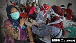 Vaksinasi sekitar 3.500 pekerja dan warga di Kawasan Berikat Nusantara di Cakung, Jakarta, tanggal 1 Juli 2021. (Courtesy: BNPB)