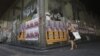 A woman walks past a closed shop with election campaign posters of Democratic Left party and radical left SYRIZA party on it in central Athens June 14, 2012.