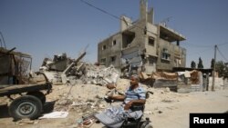 Guru matematika Palestina Ali Wahdan menggerakkan kursi rodanya melewati reruntuhan rumahnya, yang menurut saksi hancur akibat serangan Israel musim panas lalu, di Beit Hanoun, Jalur Gaza Utara, 6 Juli 2015.