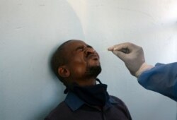 A man undergoes a COVID-19 test at a mobile clinic at a taxi rank, in Johannesburg's main railway station, Dec. 24, 2020.