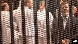 FILE - A Nov. 2013 image made from video provided by Egypt's Interior Ministry shows ousted President Mohammed Morsi (R), speaking from the defendant's cage during a trial hearing in Cairo, Egypt.