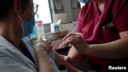 Seorang petugas kesehatan menyuntikkan vaksin COVID-19 buatan Oxford-AstraZeneca di Rumah Sakit Foch di Suresnes, dekat Paris, Perancis France, Feb. 8, 2021. 