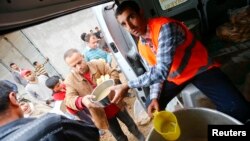 16일 터키 수루크의 난민캠프에서 터키 구호요원들이 시리아 코바니 출신 난민들에게 식량을 나눠주고 있다.