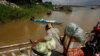 A vendor, foreground, stands on a ferry together with his goods before crossing the Mekong river in Dei Edth village at the outskirt of Phnom Penh, Cambodia, July 22, 2020. 