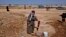 An elderly Syrian woman, who fled her home due to government shelling, washes her laundry in tub, as she takes refuge at Bab Al-Salameh crossing border near the Syrian town of Azaz, September 13, 2012. 