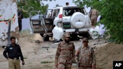 Pakistani security officials stand guard at the site of a suicide bombing which killed dozens of people and left many injured in Mastung district near Quetta, Pakistan, May 12, 2017.