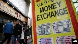 Orang-orang melewati toko tempat penukaran uang di Seoul, Korea Selatan. (Foto: AP)