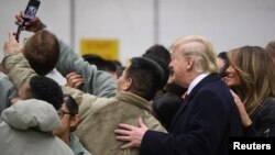 Presiden AS Donald Trump dan ibu negara Melania Trump berfoto dengan pasukan AS di Pangkalan Angkatan Udara Ramstein, Jerman, 27 Desember 2018. (Foto: Reuters)