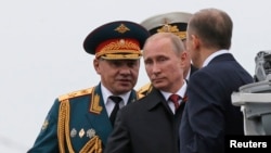 Russian President Vladimir Putin (C) and Defence Minister Sergei Shoigu (L) review the Russian fleet in Sevastopol May 9, 2014.