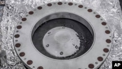 ​ຮູບນີ້ ທີ່​ສະ​ໜອງ​ໂດຍອ​ົງ​ການ​ນາ​ຊາ ເມື່ອ​ວັນ​ທີ 11 ຕຸ​ລາ 2023 ສະ​ແດງ​ໃຫ້​ເຫັນ​ຂ້າງນອກ ຂອງ​ເຄື່ອງ​ເກັບ​ຕົວ​ຢ່າງ ຝຸ່ນ​ແລະ​ກ້ອນ​ຫີນ Osiris-Rex ຈາກ​ດາວ​ເຄາະ​ນ້ອຍ ເບັນ​ນູ (Bennu). ຕົວ​ຢ່າງ​ສ່ວນ​ໃຫຍ່​ແມ່ນ​ຢູ່​ຂ້າງ​ໃນ. (NASA via AP)