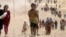 FILE - Children from the minority Yazidi sect, fleeing violence from Islamic State militants in Sinjar, Iraq, make their way toward the town of Elierbeh of Al-Hasakah Governorate, near the Syrian border, Aug. 10, 2014. 