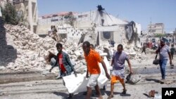 Rescuers carry away the dead body of a civilian who was killed in a blast in Mogadishu, Somalia, Jan. 12, 2022. 